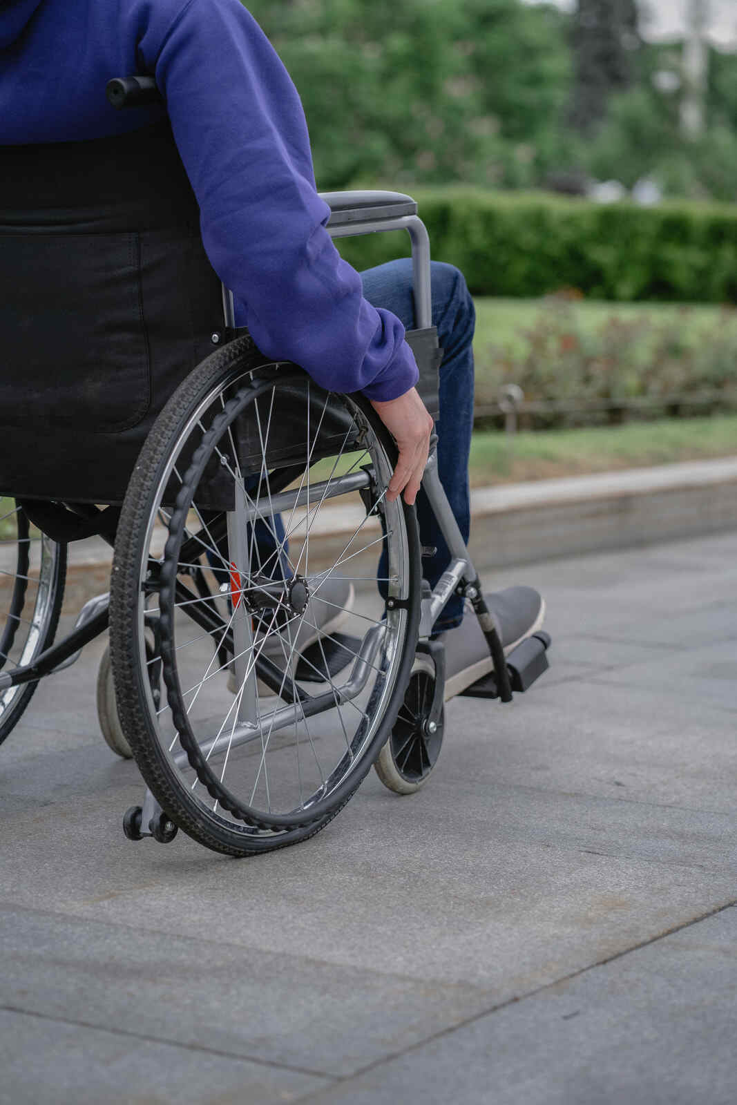 Person using a wheelchair on a paved pathway, symbolizing mobility support in holistic Ayurvedic MS treatment in Hyderabad.
