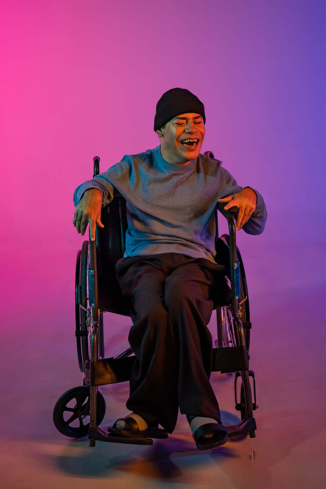 Person in a wheelchair smiling, against a colorful gradient background, representing improved quality of life through holistic Ayurvedic MS treatment in Hyderabad.
