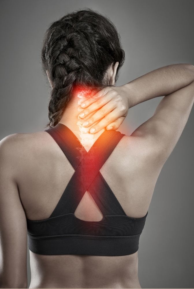 Woman with braided hair experiencing neck pain, highlighted in red, representing discomfort and seeking Ayurvedic treatment and herbal therapy in Hyderabad. Yoga practices may also be beneficial for relief in 2025.